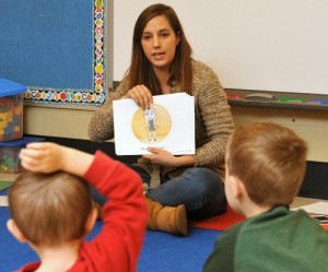 SUNY Oswego senior psychology major Holly Santimaw shows a picture of a child in a bubble of personal space to reinforce a social-skills lesson for pre-kindergarteners in Margaret Talamos class at Minetto Elementary School. The lesson was part of a project in Oswego schools directed by Matthew Dykas of the college's psychology department and staffed by interns.